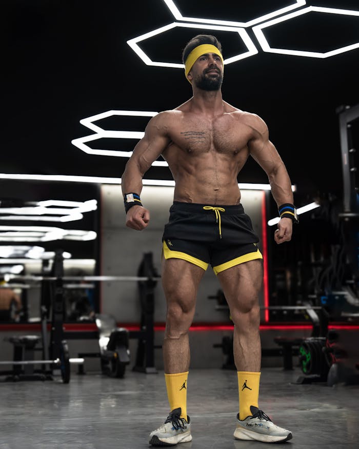 Athletic male posing in a modern gym, showcasing fitness and strength.